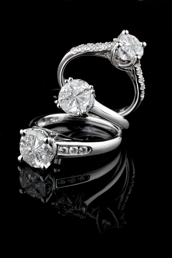 Three white gold diamond rings on black background